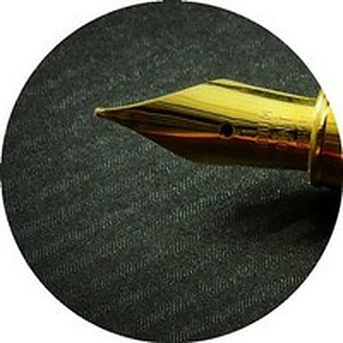 Plume d'un stylo en or sur un tissu sombre